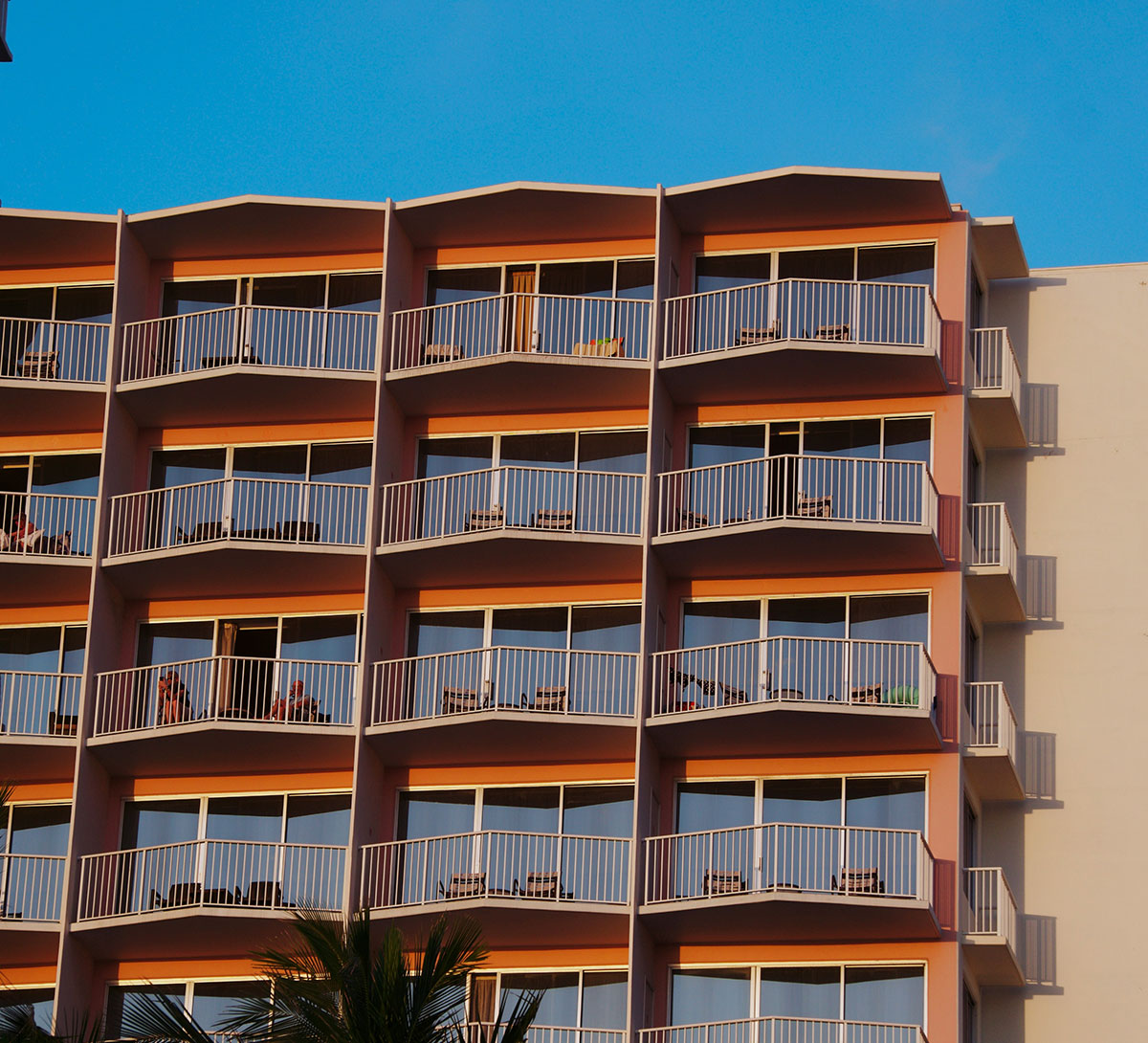 Apartment building with rows of balconies in warm evening light