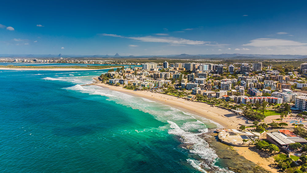 Aerial view of a sandy coastline and coastal apartment buildings