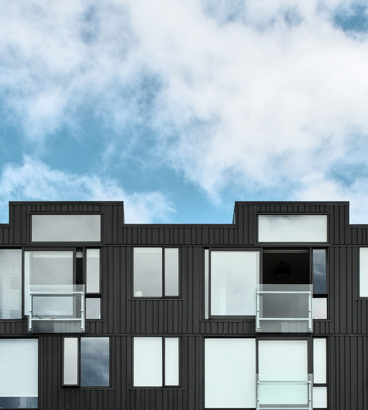Modern dark-clad apartment building with glass balconies